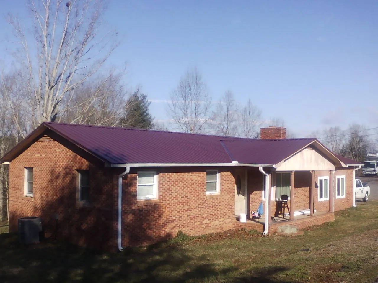Burgundy metal roof on a brick ranch home with a new addition in Marne
